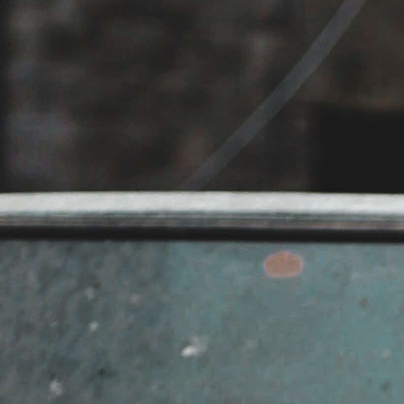 Persona clasificando piezas de chatarra metálica en un punto de venta en Navarra, balanza y documentos de requisitos sobre la mesa